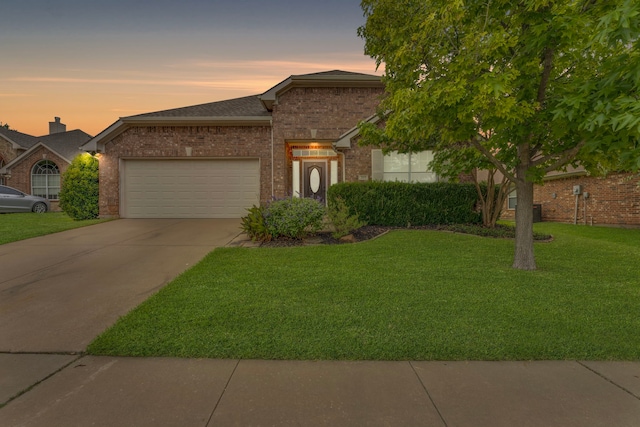 view of front of property with a garage and a lawn