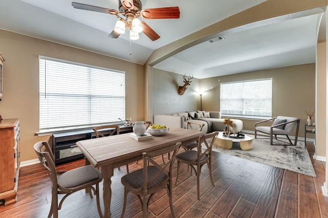 dining space featuring ceiling fan, vaulted ceiling, and dark hardwood / wood-style flooring