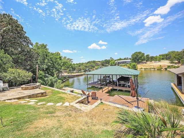 dock area with a water view, a yard, and a fire pit