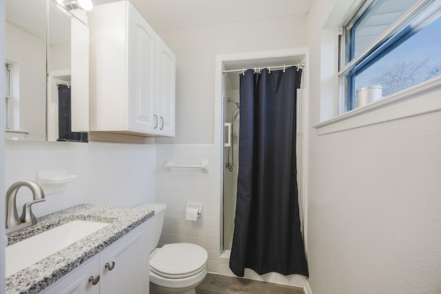 bathroom featuring a shower with curtain, vanity, tile walls, and toilet