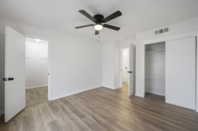 unfurnished bedroom featuring a closet, visible vents, light wood-style flooring, ceiling fan, and baseboards