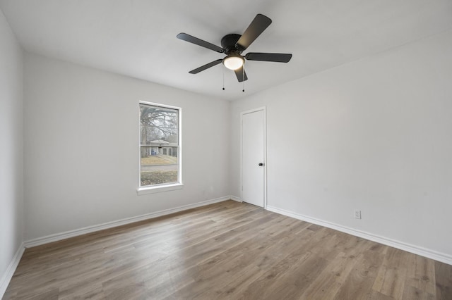 unfurnished room with ceiling fan, light wood-style flooring, and baseboards