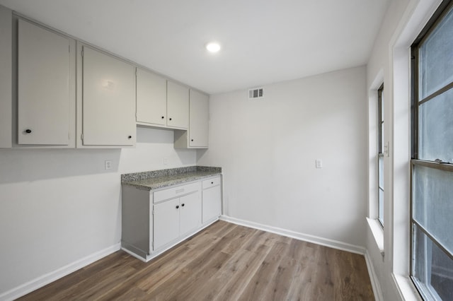 kitchen featuring a wealth of natural light, visible vents, light wood finished floors, and white cabinetry