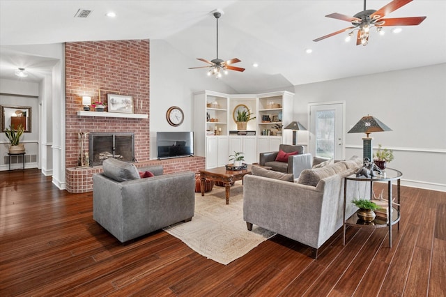 living room featuring ceiling fan, dark hardwood / wood-style flooring, vaulted ceiling, and a brick fireplace