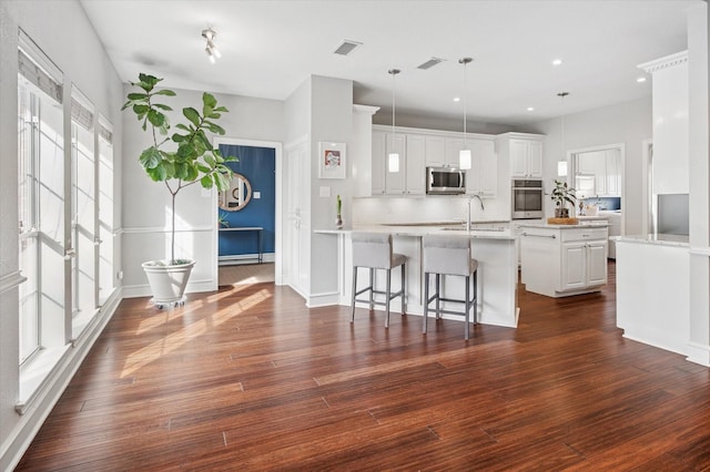 kitchen featuring a kitchen island, pendant lighting, white cabinetry, sink, and stainless steel appliances