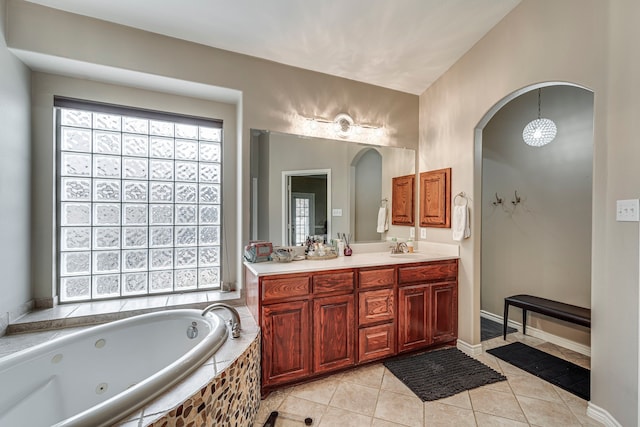 bathroom featuring tile patterned flooring, vanity, and a whirlpool tub