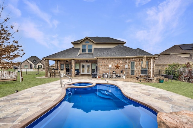 view of pool featuring a pool with connected hot tub, a fenced backyard, french doors, a yard, and a patio area