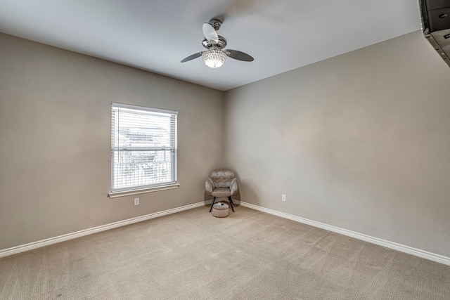 unfurnished room featuring baseboards, light carpet, and ceiling fan