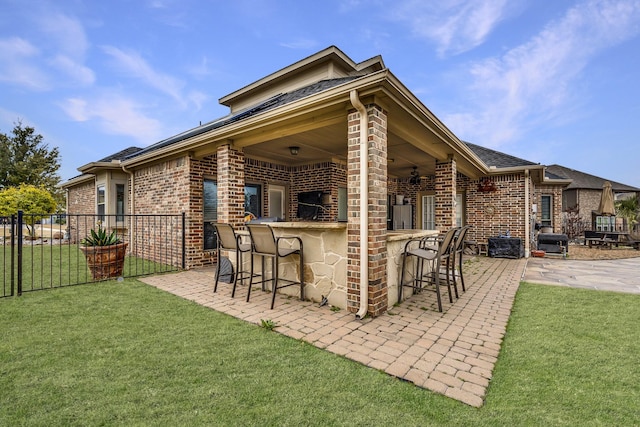 view of patio with outdoor dry bar and fence