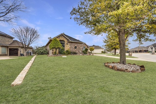 view of front facade with a front yard, brick siding, and driveway