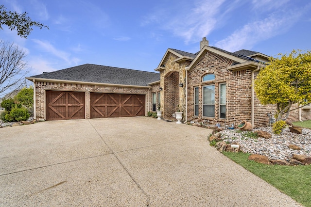 ranch-style house featuring brick siding, driveway, an attached garage, and roof with shingles