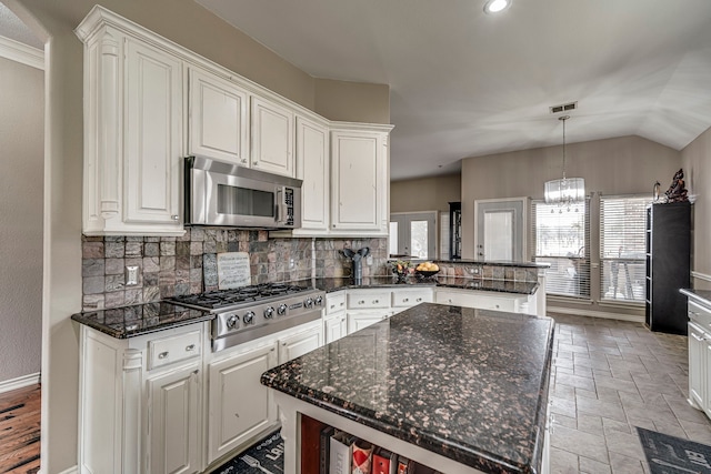 kitchen with a wealth of natural light, white cabinets, and appliances with stainless steel finishes