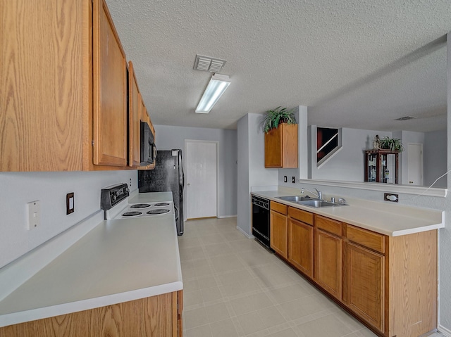 kitchen featuring light floors, visible vents, brown cabinetry, a sink, and black appliances