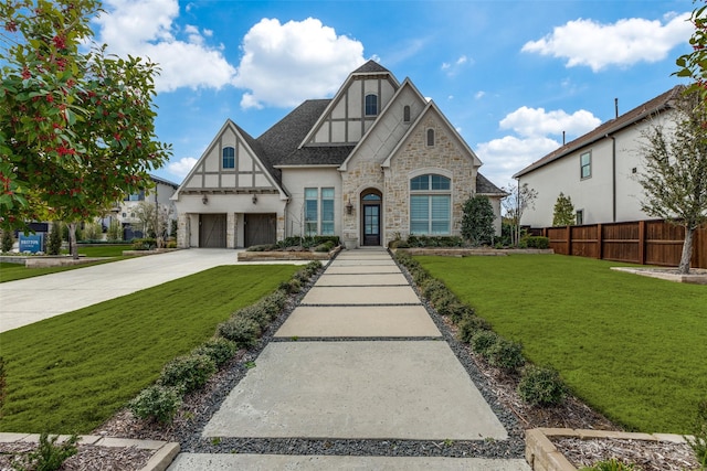 english style home with a garage and a front lawn