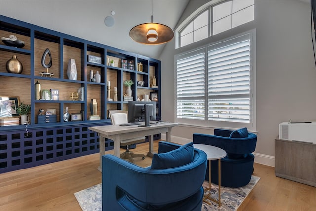 home office with high vaulted ceiling and light wood-type flooring