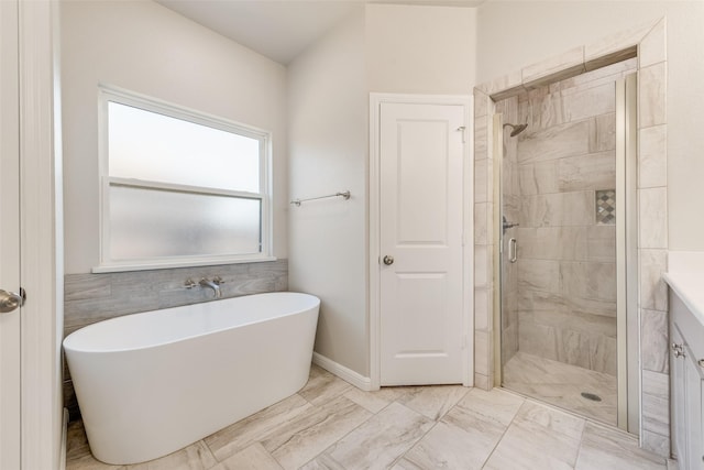 bathroom featuring vanity and independent shower and bath