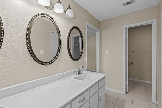 bathroom featuring vanity, tile patterned flooring, visible vents, and baseboards