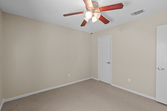 carpeted spare room with ceiling fan, visible vents, and baseboards