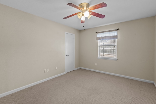 unfurnished room with a ceiling fan, light carpet, and baseboards