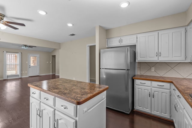 kitchen with tasteful backsplash, visible vents, open floor plan, freestanding refrigerator, and white cabinetry