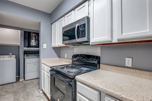 kitchen featuring black range with electric stovetop, stainless steel microwave, and white cabinetry