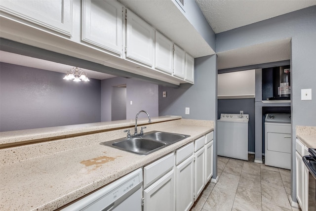 kitchen with light countertops, independent washer and dryer, a sink, and white cabinets