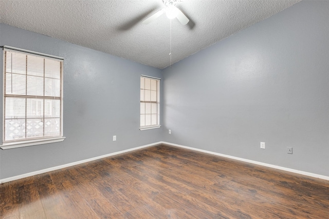 empty room featuring dark wood-style floors, baseboards, and a textured ceiling