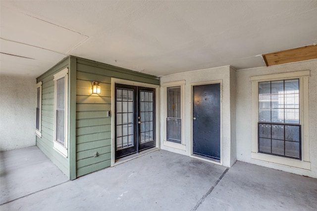 view of exterior entry featuring french doors and a patio area