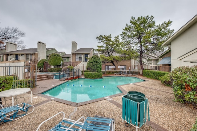 pool with a residential view, a patio area, and fence