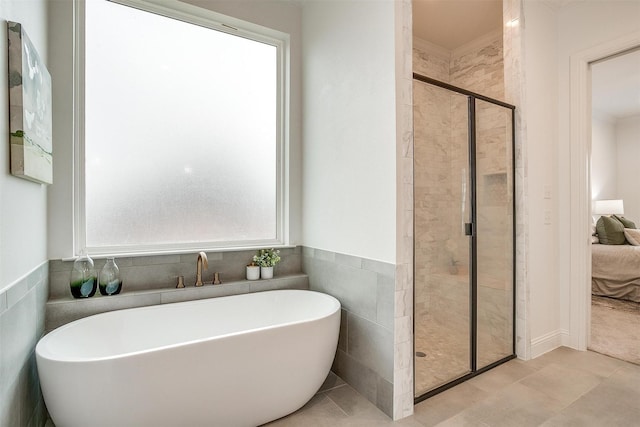 bathroom featuring separate shower and tub and tile walls