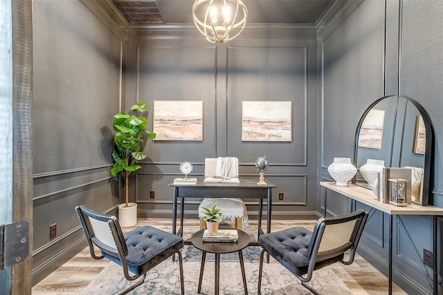 living area featuring ornamental molding, an inviting chandelier, and light wood-type flooring