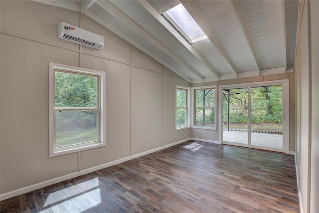 spare room featuring hardwood / wood-style flooring, lofted ceiling with skylight, a wall unit AC, and a wealth of natural light