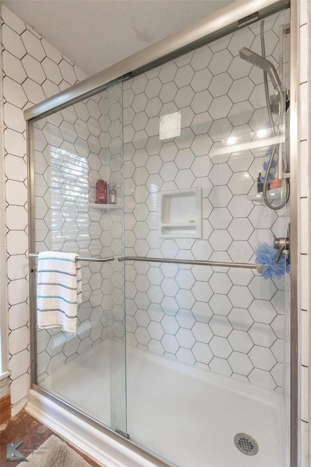 bathroom with a shower with door