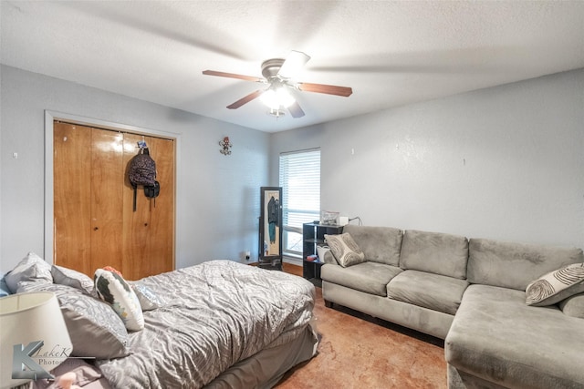 bedroom featuring ceiling fan, light colored carpet, a closet, and a textured ceiling