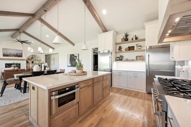 kitchen featuring a center island, pendant lighting, light countertops, white cabinets, and wall chimney exhaust hood