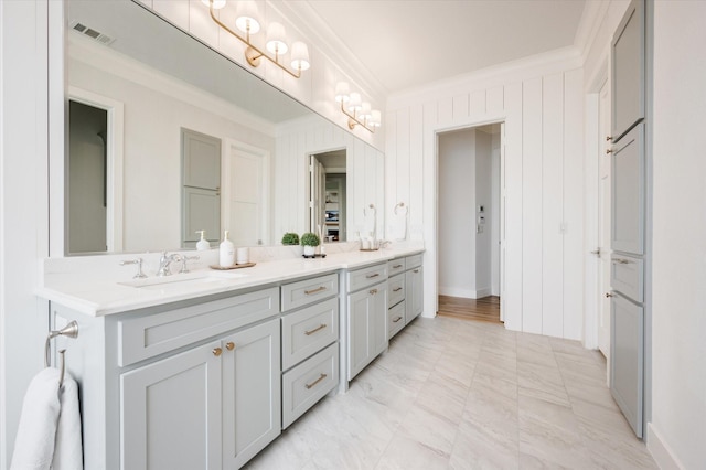 full bathroom with double vanity, a sink, visible vents, and crown molding