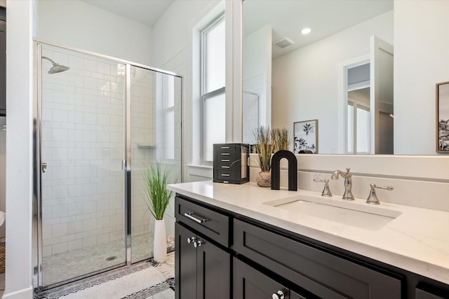 bathroom featuring visible vents, vanity, and a shower stall