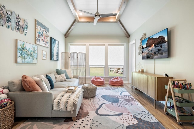 living room with lofted ceiling with beams, wood finished floors, and a ceiling fan