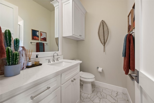 bathroom featuring marble finish floor, toilet, vanity, and baseboards