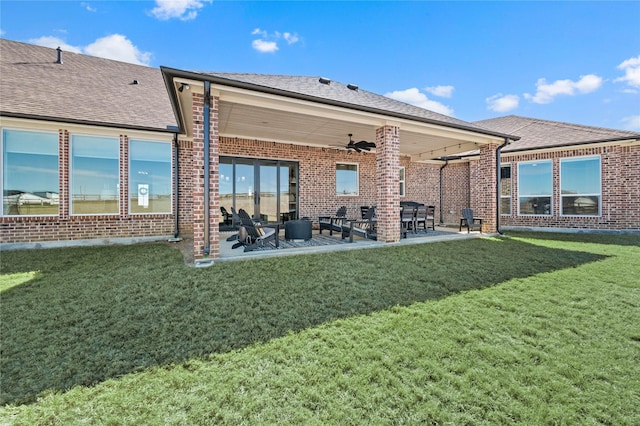 back of property with brick siding, a patio, and roof with shingles