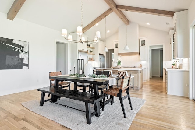 dining area featuring a chandelier, beam ceiling, high vaulted ceiling, and light wood-style flooring