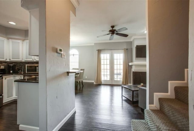 interior space with crown molding, dark wood-type flooring, and ceiling fan