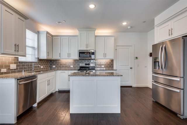 kitchen featuring a center island, stainless steel appliances, light stone countertops, and sink