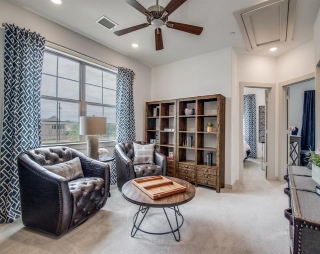 sitting room with ceiling fan and light carpet