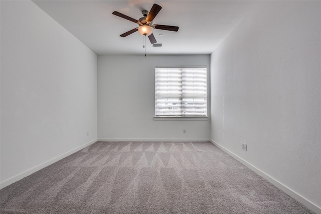 spare room with ceiling fan and light colored carpet