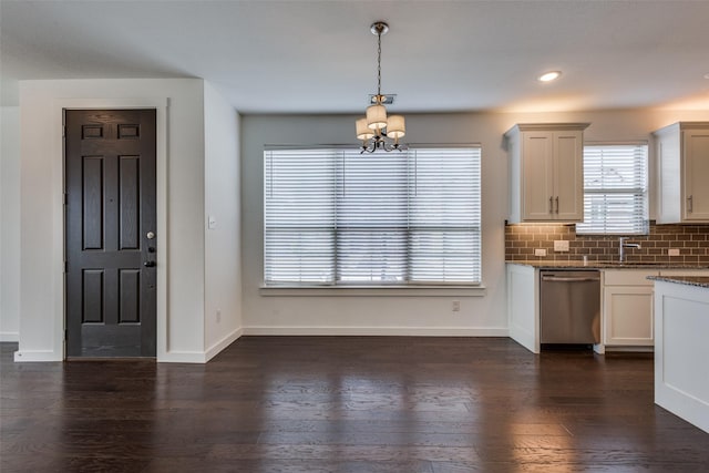 kitchen featuring white cabinetry, hanging light fixtures, dark hardwood / wood-style floors, tasteful backsplash, and stainless steel dishwasher