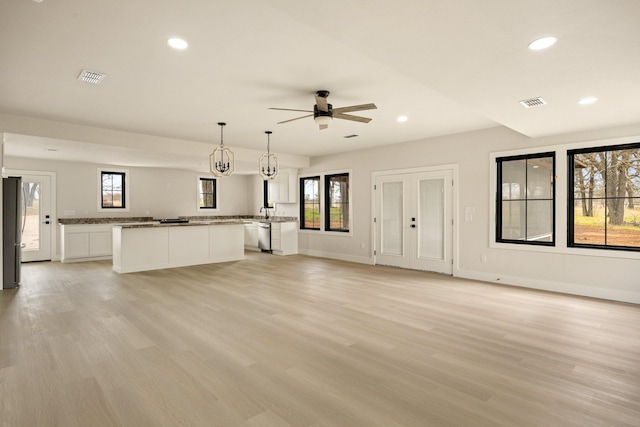 unfurnished living room featuring ceiling fan and light hardwood / wood-style flooring