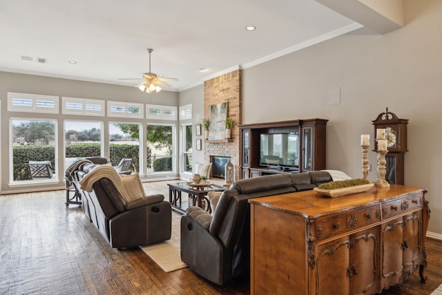 living room featuring dark hardwood / wood-style flooring, ceiling fan, and a brick fireplace