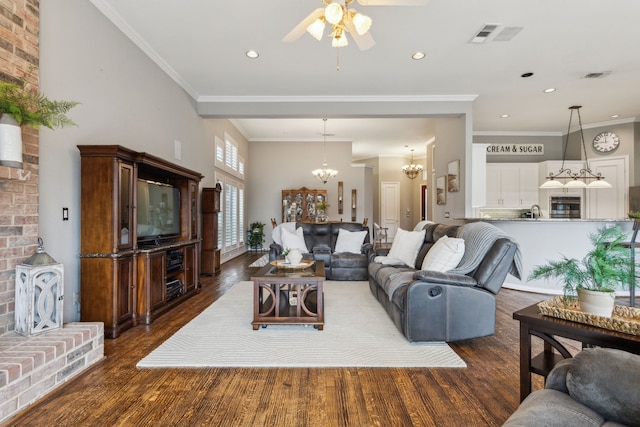 living room featuring dark hardwood / wood-style flooring, sink, crown molding, and ceiling fan with notable chandelier