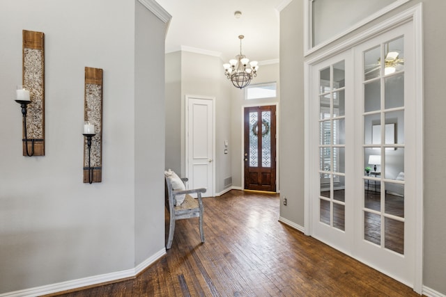 entryway featuring a notable chandelier, crown molding, and dark hardwood / wood-style floors